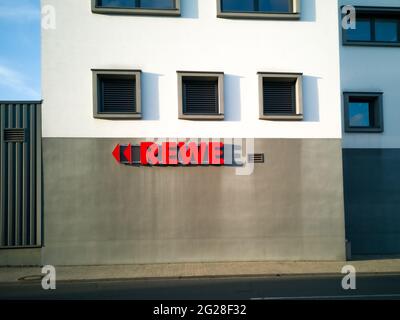 NEUWIED, DEUTSCHLAND - 12. Nov 2020: Neuwied, Deutschland - 12. November 2020: Rotes REWE Label mit Dreiecken als Richtungszeichen außen an einer Wand - copy Spa Stockfoto