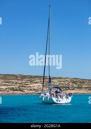 Insel Koufonisi, Strand Pori, Kykladen, Griechenland. 22.Mai 2021. Festgemacht weiße Yacht in der Mitte der Ägäis ruhigen Meer blauen Himmel Hintergrund. Sonniger Sommer da Stockfoto