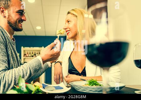 Porträt von attraktiv, niedlich, süß, schön, festlich, Fröhliches Paar. Mann füttert seine Frau, gibt Essen mit Gabel, Spaß haben. Essen und Liebe Konzept Stockfoto