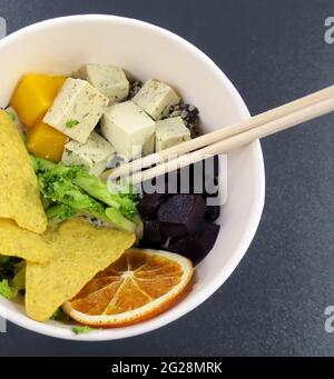 Salat mit Tofu, Quinoa, Mango, Rote Bete, Brokkoli, Orange und Chips Stockfoto