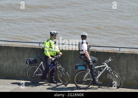 Zwei Polizisten aus Newham MPS auf einer Fahrradpatrouille, die Gallions Point im Londoner Royal Docks-Viertel besucht Stockfoto