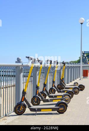 Elektroroller, die am Wasser geparkt sind, können gemietet werden. Stockfoto