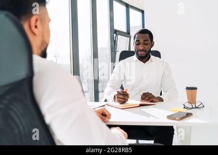 Der Unternehmensleiter führt ein Interview für einen Mann durch Stockfoto