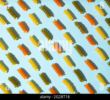 Kreatives Muster aus spiralförmigen Makkaroni auf pastellblauem Hintergrund. Stockfoto