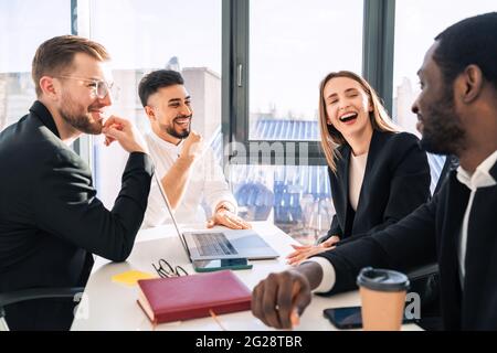 Fröhliche Mitarbeiter eines Finanzunternehmens in einem Büro bei einem Geschäftstreffen Stockfoto