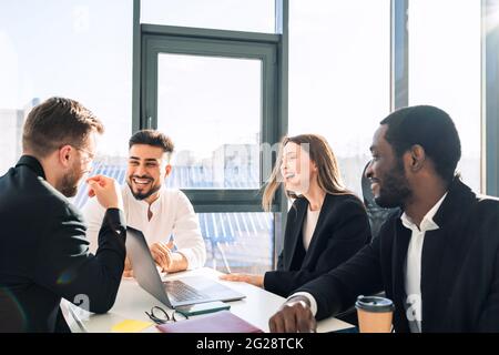 Fröhliche Mitarbeiter eines Finanzunternehmens in einem Büro bei einem Geschäftstreffen Stockfoto