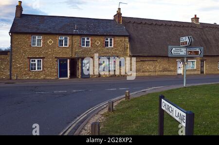 Geschäfte und Ferienhäuser im Dorfgrün in Sharnbrook, Bedfordhire, England, Großbritannien Stockfoto