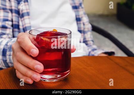 Nahaufnahme einer männlichen Hand mit einem Glas Alkohol-Cocktail Stockfoto