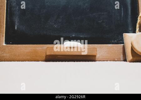 Nahaufnahme einer kleinen Tafel mit einem Holzrahmen und Kreide auf einer weißen Oberfläche Stockfoto