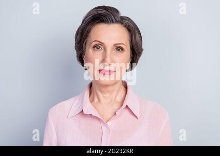 Nahaufnahme Porträt von attraktiven Inhalt qualifizierte Frau trägt rosa pastellfarbene Hemd isoliert auf grauem Hintergrund Stockfoto