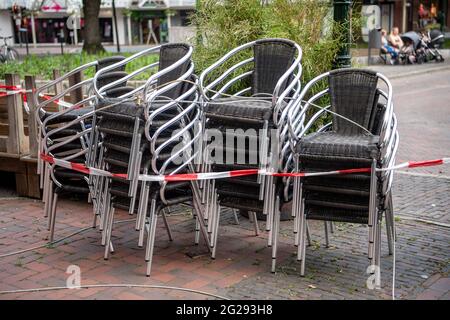 Emden, Deutschland. Juni 2021. Verschlossene Stühle stehen vor einem geschlossenen Restaurant im Stadtzentrum. Nach Wochen einer angespannten Lage in Corona gilt die Stadt Emden ab diesem Freitag (0 Uhr) nicht mehr als hochaktuelle Gemeinde. Die Hafenstadt in Ostfriesland blieb nach Angaben der Stadtverwaltung am Mittwoch zum fünften Mal in Folge unter einer siebentägigen Inzidenz von 100 Tagen. Daher soll die Ausgangssperre, die in der sogenannten Bundesnotbremse festgelegt wurde, ab Freitag aufgehoben werden. Quelle: Sina Schuldt/dpa/Alamy Live News Stockfoto