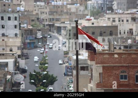 Taiz Jemen - 22 Aug 2016 : jemenitische Flagge vor Gebäuden, die durch den Krieg gegen die Stadt Taiz zerstört wurden Stockfoto