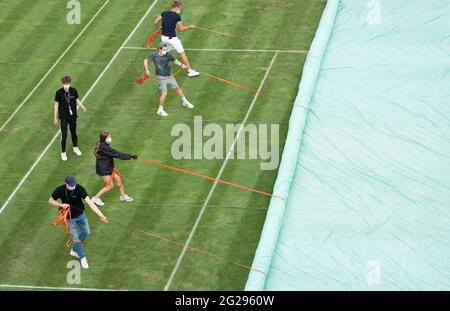 Stuttgart, Deutschland. Juni 2021. Tennis: ATP Tour - Stuttgart, Herren-Singles, 1. Runde. Helfer decken den Center Court während einer Regenpause ab. Quelle: Marijan Murat/dpa/Alamy Live News Stockfoto