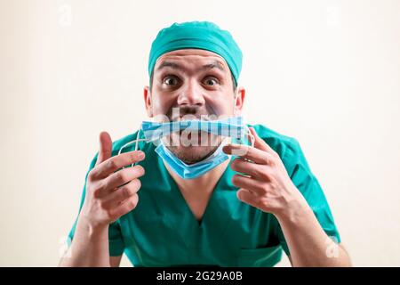 Lustiger Arzt mit einer medizinischen Maske in den Händen. Stockfoto