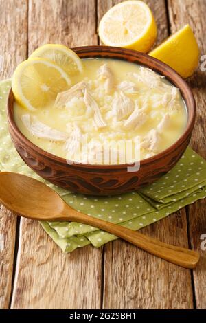 Kotosoupa ist eine leckere und herzhafte griechische Hühnersuppe aus der Nähe auf dem Teller auf dem Tisch. Vertikal Stockfoto