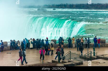 Touristen, die entlang gehen und die wunderschöne Aussicht auf den Horseshoe Fall in Niagara Falls genießen, eine der wichtigsten Touristenattraktionen in Kanada Stockfoto
