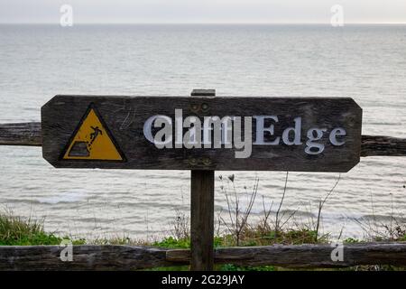 Ein Schild, das vor der Gefahr durch die Klippe in der Nähe von Beachy Head, Eastbourne, warnt. Stockfoto