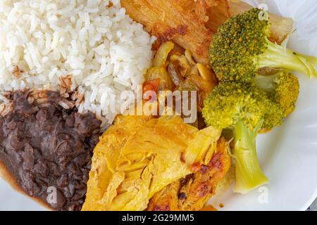 Typisch brasilianisches Gericht mit Reis und Bohnen sowie Salat und Hühnerfleisch. Hausgemachte Speisen. Tägliches Kochen. Gericht fertig. Teller mit Essen zum Mittagessen serviert. Homem Stockfoto