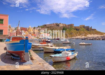Panoramablick auf Procida, italienische Kulturhauptstadt 2022: Bunte Häuser, Cafés und Restaurants, Fischerboote und Yachten in Marina Corricella. Stockfoto