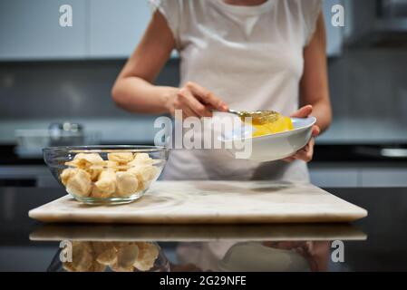 Frau, die Eier für ein Bananenpfannkuchen-Rezept hastert Stockfoto