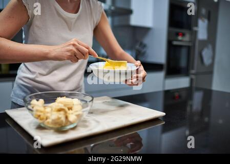 Frau, die Eier für ein Bananenpfannkuchen-Rezept hastert Stockfoto