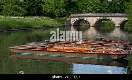 Leere Holzpanzer werden am Ufer des Flusses Cam in Cambridge vertäut. Im Hintergrund ist die Dreifaltigkeitsbrücke. Auf dem Bild sind keine Personen zu sehen Stockfoto