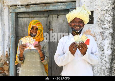 Beawar, Indien. Juni 2021. Die Begünstigten zeigen Geld, das sie als COVID-Entlastung von der Regierung von Rajasthan außerhalb einer Bank im Dorf Liri in der Nähe von Beawar erhalten haben. Chief Minister Ashok Gehlot führte Rajasthan Regierung veröffentlicht RS 1000 je für 33 lakh Familien schwer von Coronavirus getroffen. Der Staatsgovt hatte im vergangenen Jahr in drei Raten eine finanzielle Unterstützung von 3,500 Rs an 33 lakh hilflose, mittellose und von COVID-19 betroffene Arbeiterfamilien geleistet. (Foto: Sumit Saleswat/Pacific Press) Quelle: Pacific Press Media Production Corp./Alamy Live News Stockfoto