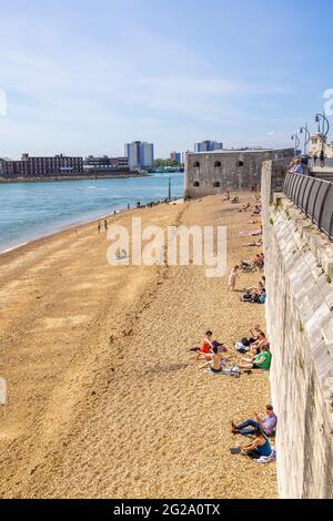 Sonnenanbeter am Kiesstrand genießen die Sonne in Hotwalls, Teil von Point Battery und Barracks in Old Portsmouth, Hampshire, Südküste Englands Stockfoto