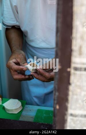 Beschnittene anonyme Person, die Dim Sum alten Stil macht Stockfoto
