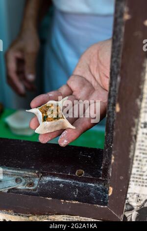 Beschnittene anonyme Person, die Dim Sum alten Stil macht Stockfoto
