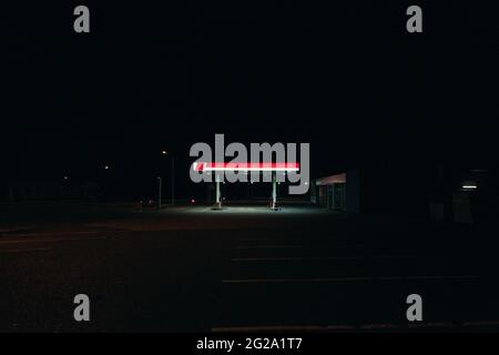 Beleuchtetes Gebäude der roten modernen Tankstelle in totaler Dunkelheit der isländischen Landschaft Stockfoto