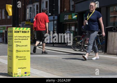 Wokingham, Großbritannien. Juni 2021. Anwohner passieren eine öffentliche Informationsanzeige von Covid-19, während die lokale Besorgnis über die Ausbreitung der Delta-Variante zunimmt. In einigen lokalen Postleitzahlen wurden Surge-Tests eingeführt, nachdem eine kleine Anzahl von Fällen der erstmals in Indien identifizierten Delta-Variante im Gebiet Wokingham bestätigt wurde. Kredit: Mark Kerrison/Alamy Live Nachrichten Stockfoto