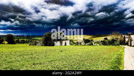 Panorama-Aufnahme von grünen Grasfeldern unter einem dunklen dramatischen bewölkten Himmel Stockfoto