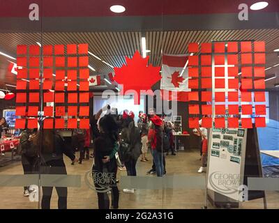 Toronto, Kanada - 29. Juni 2017: Blick auf den ESL Campus voller Studenten, die den Canada Day im George Brown College feiern. DIY Canada Flagge auf dem Fenster. Stockfoto