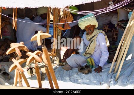 Pushkar, Indien - 10. November 2016: Ein rajasthani Mann mit Turban Verkauf Kamel verwandte Holzwaren auf dem kommerziellen Markt der Pushkar fair oder mela i Stockfoto