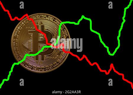 Wertvolle goldene Bitcoin auf dunkelschwarzem Hintergrund rot und grün fallen oder steigen Charts Stockfoto