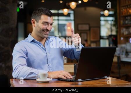 Geschäftsmann in einer Videokonferenz winkt auf dem Bildschirm Stockfoto