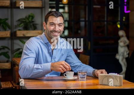 Junger latein in einem Café, der einen Kaffee trinkt Stockfoto