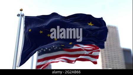 Die Flaggen des Staates Alaska und der Vereinigten Staaten von Amerika winken im Wind. Demokratie und Unabhängigkeit. US-Bundesstaat. Stockfoto