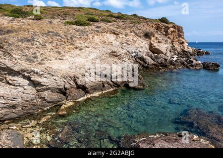 Wildes mittelmeer mit felsigen Klippen und blauem klarem Wasser. Reisen Sie nach Griechenland in der Nähe von Athen. Sommer Natur szenische Lagune Stockfoto