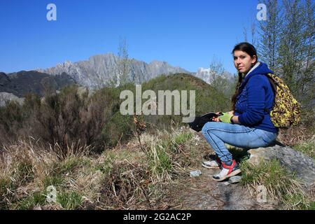 kaukasische Frau ruht müde in den Bergen nach einer langen Wanderung auf den Gipfeln des apennins apuanische alpen in der toskana Stockfoto