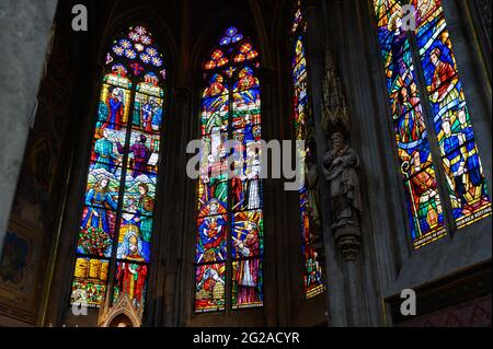 Buntglasfenster mit verschiedenen Figuren und Ereignissen in der Geschichte der Kirche im Zusammenhang mit Österreich. Votivkirche – Votivkirche, Wien. Stockfoto