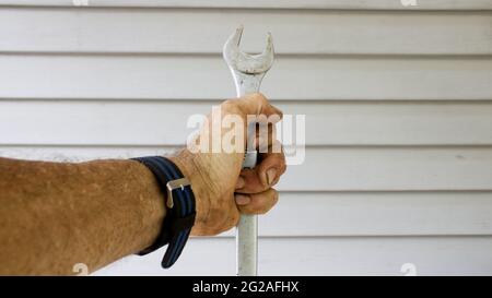 Ein Mann, der einen Schraubenschlüssel in der Hand hält Stockfoto