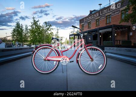 Calgary Alberta Kanada, 30 2021. Mai: Ein Vintage-Damen-Huffy-Cruiser-Fahrrad parkte an einem Abend in der Innenstadt auf einem Pfad vor einem Restaurant. Stockfoto