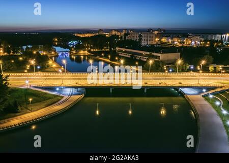 Panorama-Stadtbild bei Nacht mit Brücke über den Fluss Svisloch. Minsk, Weißrussland. Stockfoto