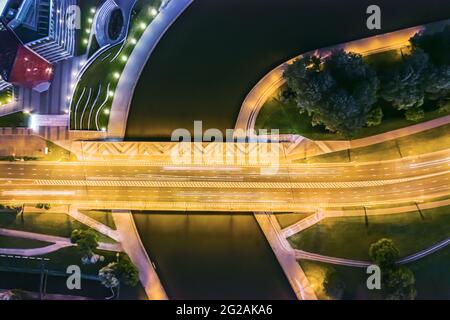 Beleuchtete Verkehrsbrücke über den Fluss Svisloch im Zentrum von Minsk. Luftaufnahme von oben. Stockfoto