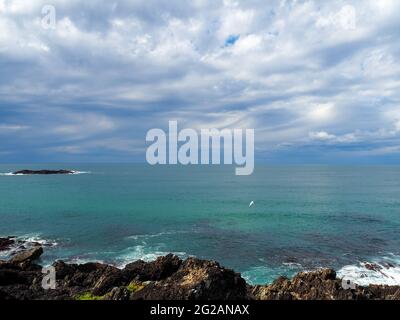 Blau-grünes türkisfarbenes Meer vor schwingenden Wolken, majestätisch am Himmel, atemberaubende australische Meereslandschaft, Pazifik bis Horizont, Sawtell, NSW Stockfoto