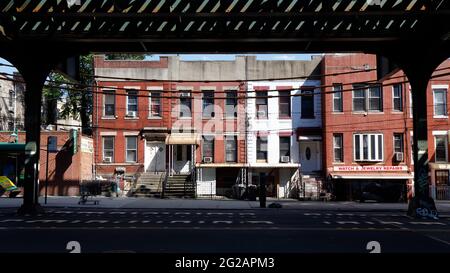 2-stöckige Wohnhäuser in der 31. St unter der erhöhten U-Bahn im Stadtteil Astoria in Queens, New York City. Stockfoto