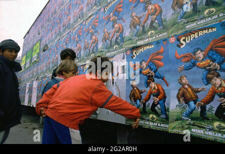 Sarajevo, Bosnien und Herzegowina. März 1997. Kinder in der Stadt schauen sich Plakate für „Superman: Deadly Legacy“ an, ein „humanitäres Comicbuch“ in einer Sonderausgabe mit Superman, das das „Bewusstsein für Landminen“ bei Kindern fördert, insbesondere aus Ländern, in denen es nach dem Krieg aktive Landminen gibt. Das Superman-Comic wurde 1996 von DC Comics, der US-Regierung und dem UNICEF (International Children's Emergency Fund) veröffentlicht. Der Bosnienkrieg, ethnisch verwurzelter Krieg in Bosnien und Herzegowina, der von 1992 bis 1995 im ehemaligen Jugoslawien stattfand. Stockfoto