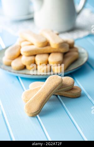 Italienischer Keks savoiardi. Süße Kekse. Biskuit-Kekse tiramisu auf blauem Tisch. Stockfoto